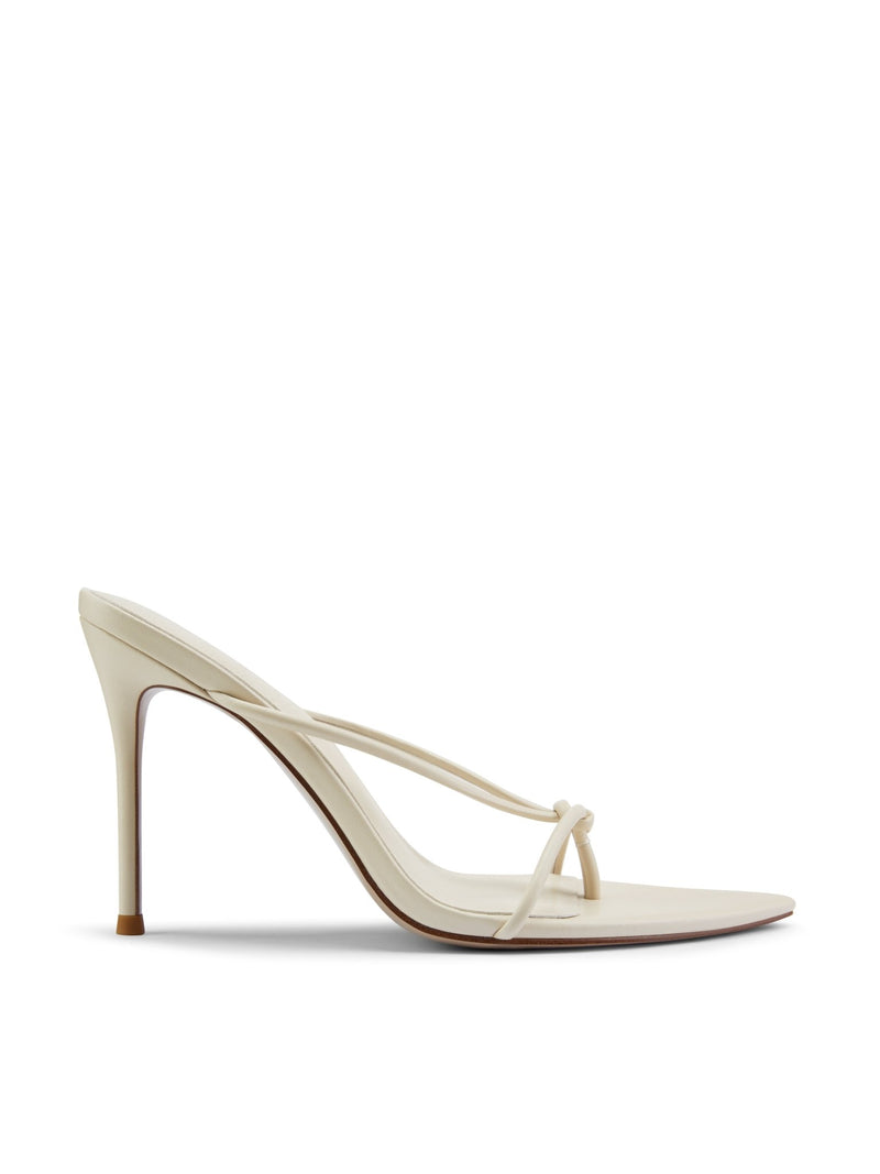 Akira Slipper in Cream – side profile of cream satin thong-strap mule with knotted toe loop and slim stiletto heel