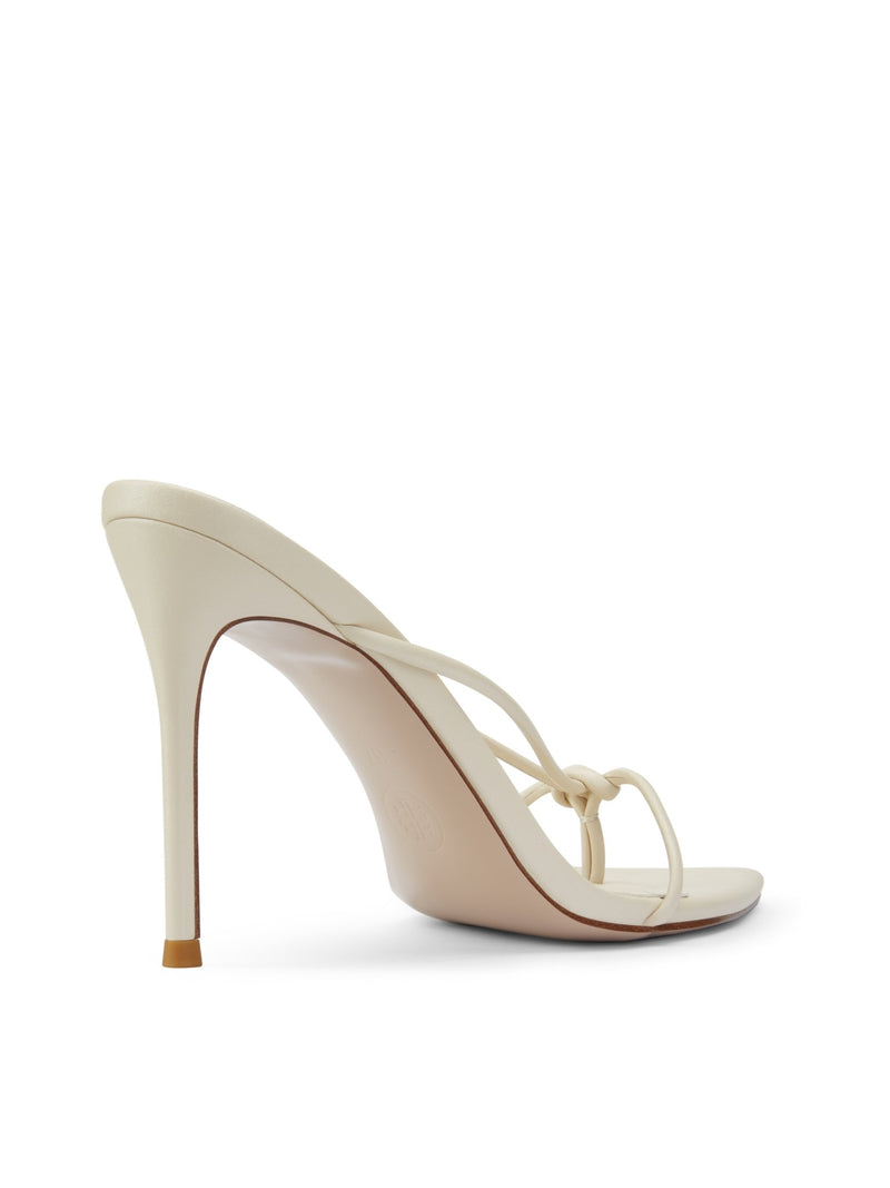 Akira Slipper in Cream – back three-quarter view of slim stiletto heel and cream satin knotted toe strap