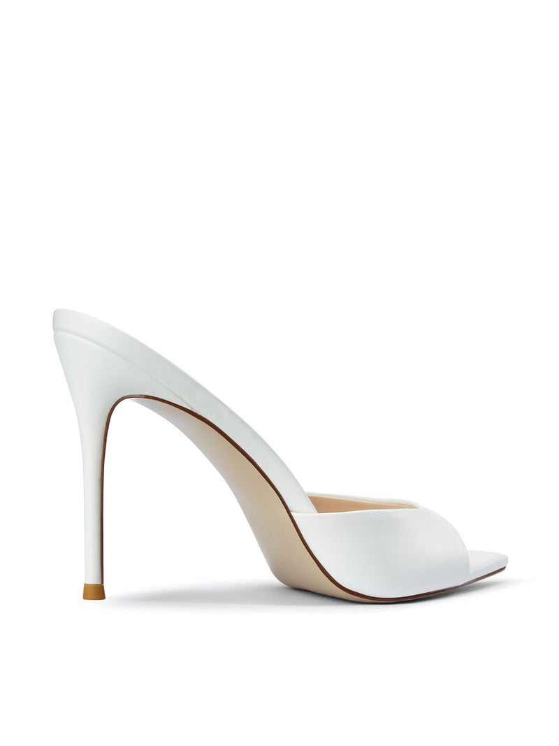 Bella Slipper in White – left side profile of white satin padded vamp curve and slim stiletto heel